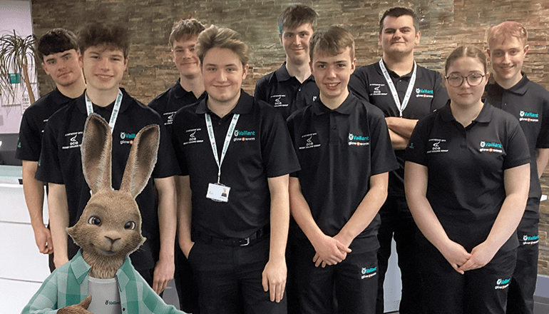 10 low carbon heating technical apprentices at Derby College with Vaillant's hare character standing in front of them