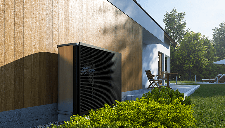 A Daikin Altherma 3 her pumps in an outdoor setting by the wall of a home