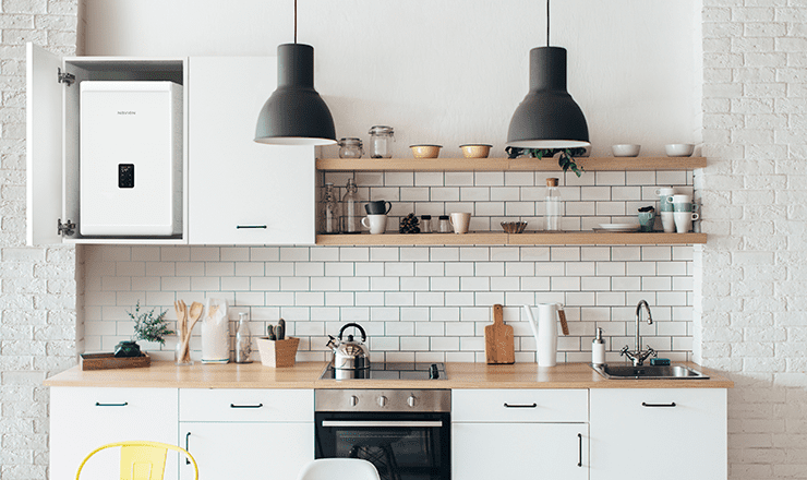 A modern kitchen setting featuring a Navien UK NCB300 boiler hung on the wall