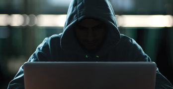 Cyber scammer at computer screen