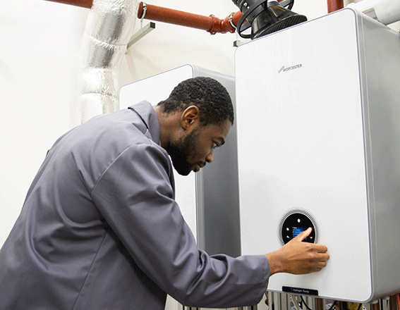 Gas engineer in front of Worcester Bosch hydrogen boiler