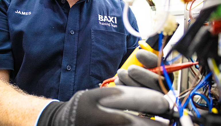 close up shot of a Baxi heating engineer working on the inside of an air source heat pump