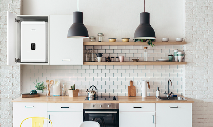 A modern kitchen setting featuring a Navien UK NCB300 boiler hung on the wall